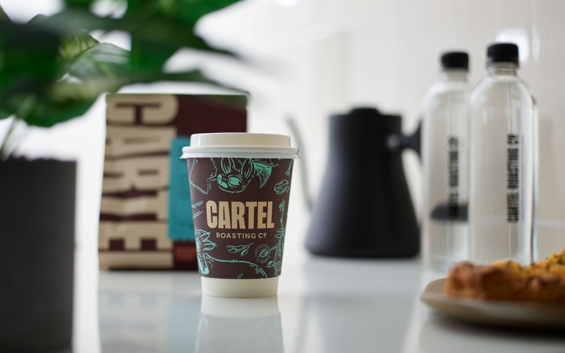 A take-out coffee on a counter at Cartel Coffee at the Camby