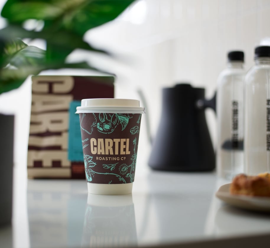 A take-out coffee on a counter at Cartel Coffee at the Camby