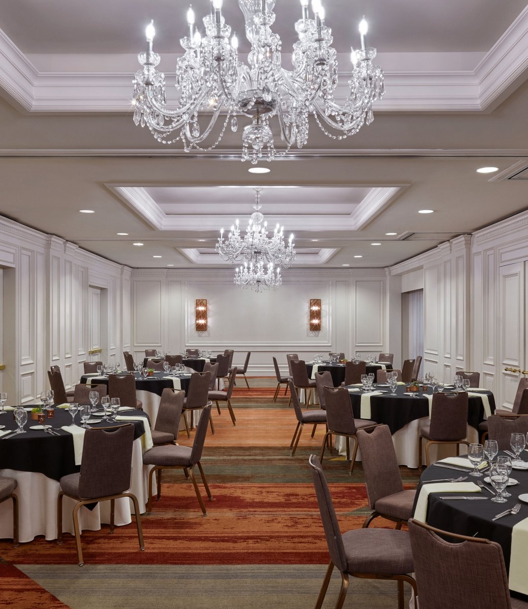 An indoor meeting space at the Camby with 6 large round tables setup for an event