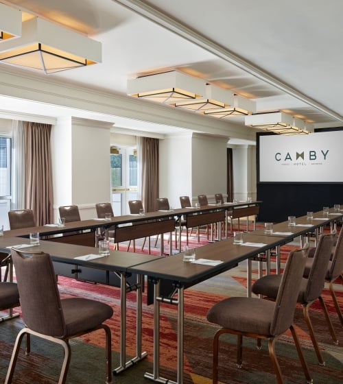 A large indoor meeting room at the Camby with tables connected in a 