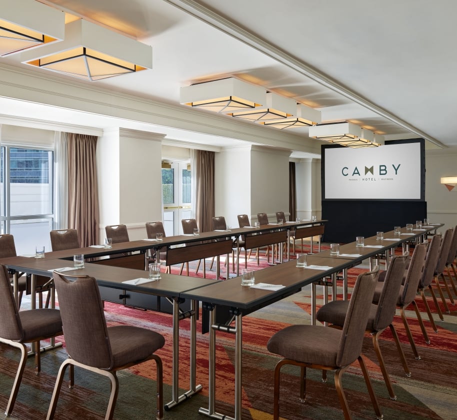 A large indoor meeting room at the Camby with tables connected in a 