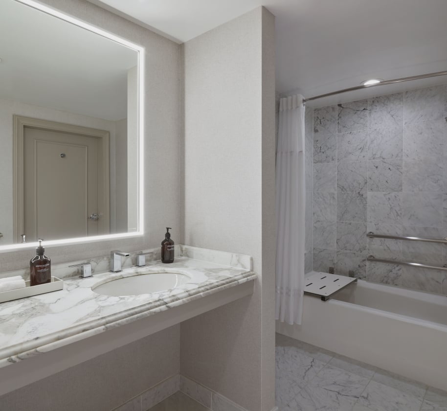 The washroom sink and tub inside the ADA room at the Camby