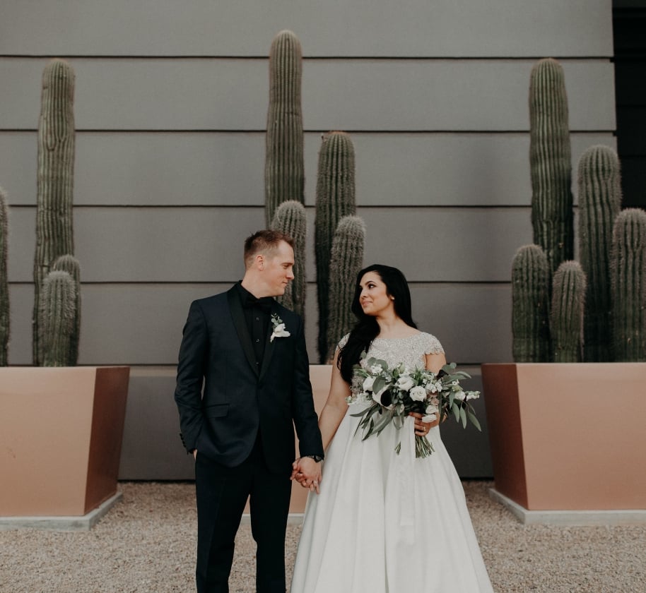 A bride and. groom holding hands at the Camby