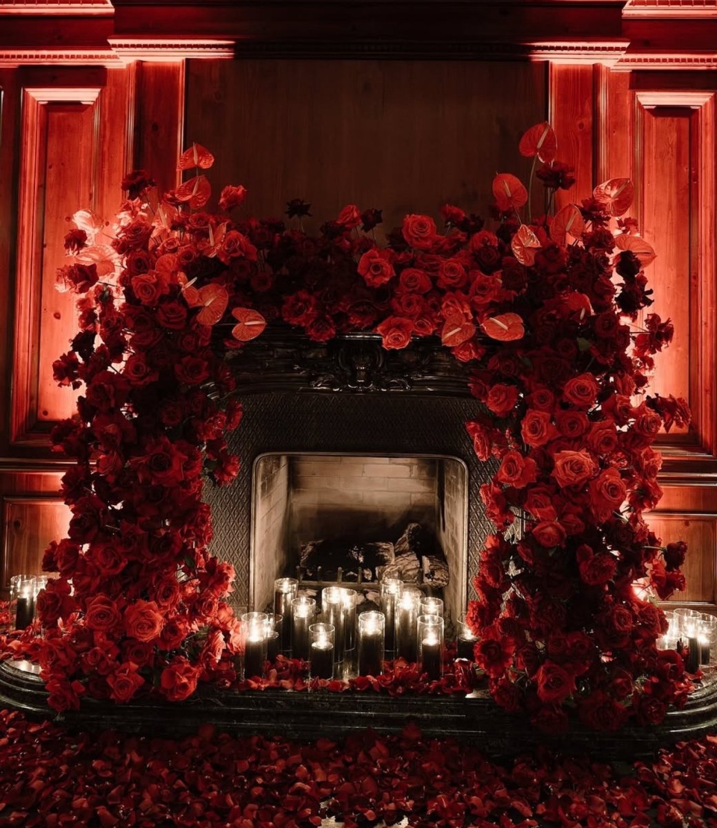 A fireplace surrounded by flowers inside Bees Knees at the Camby