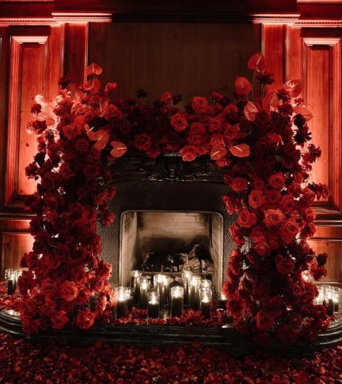 A fireplace surrounded by flowers inside Bees Knees at the Camby